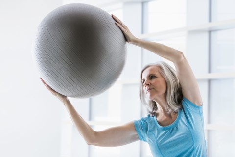 Caucasian woman leaning with fitness ball