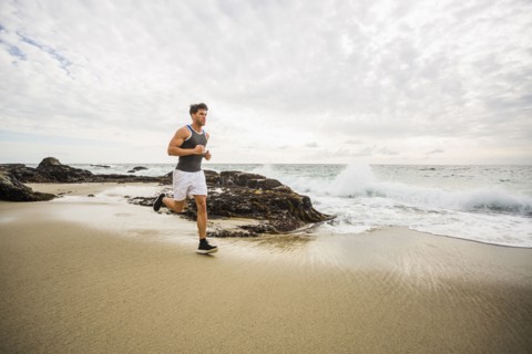 Caucasian man running on beach