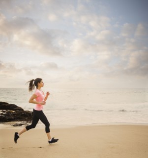 Caucasian woman running on beach