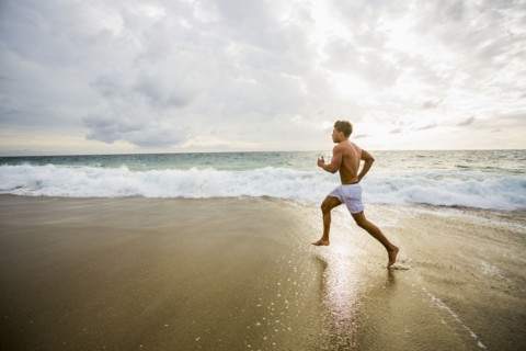Caucasian man running on beach