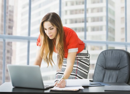 Mixed race businesswoman working at desk
