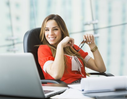Mixed race businesswoman smiling at desk