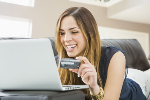 Mixed race woman shopping online on sofa