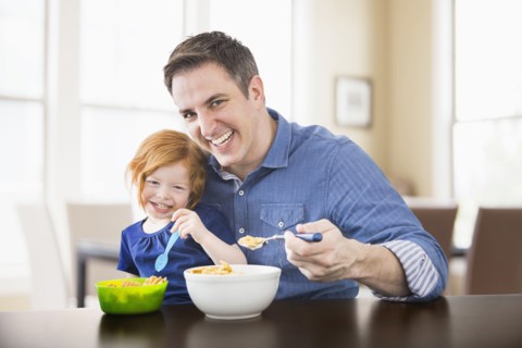 Caucasian father and daughter eating breakfast together