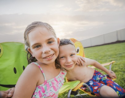 Caucasian children relaxing in lawn chairs in backyard