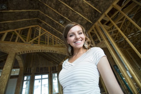 Caucasian woman smiling in house under construction