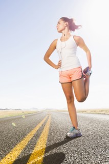 Caucasian runner stretching on remote road