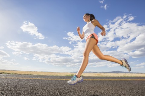 Low angle view of Caucasian woman running on remote road