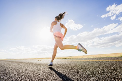 Low angle view of Caucasian woman running on remote road