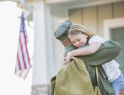 Returning Caucasian soldier hugging daughter