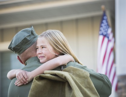 Returning Caucasian soldier hugging daughter