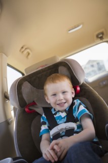 Caucasian boy smiling in car seat