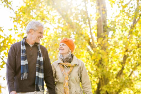 Older Caucasian couple walking near autumn trees