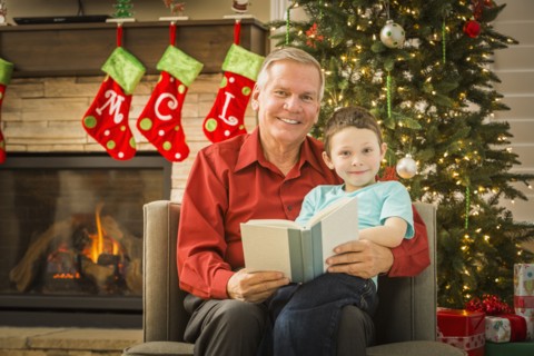 Caucasian grandfather reading to grandson at Christmas