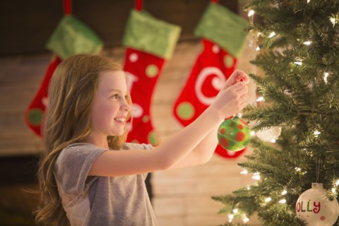 Caucasian girl decorating Christmas tree