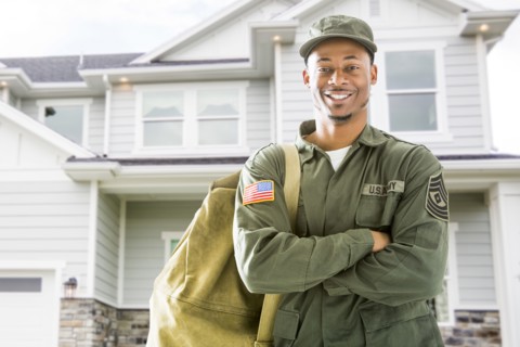Black soldier standing outside house