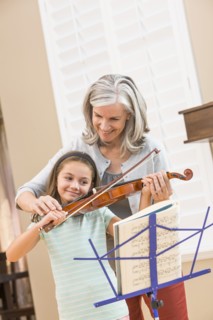 Caucasian woman giving student violin lessons