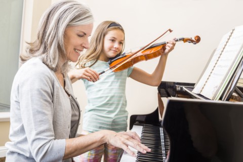 Caucasian grandmother and granddaughter playing music together