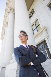 Mixed race businessman standing outside courthouse