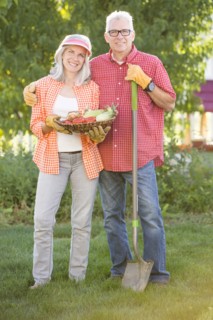 Caucasian couple gardening in backyard