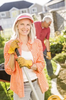 Caucasian couple gardening in backyard