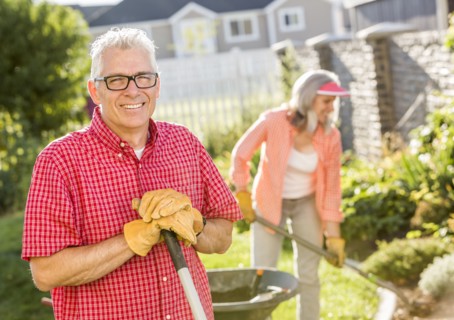 Caucasian couple gardening in backyard