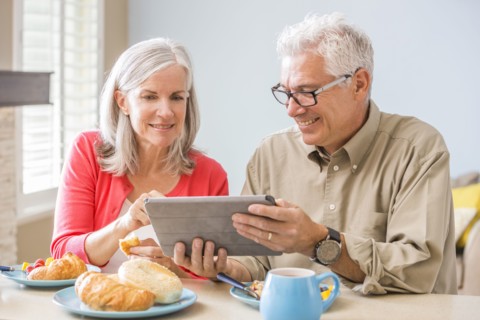 Caucasian couple using digital tablet at table