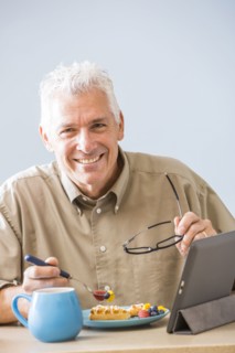 Caucasian man using digital tablet at table