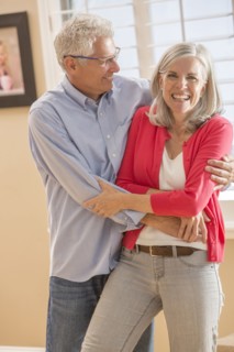 Caucasian couple dancing in living room