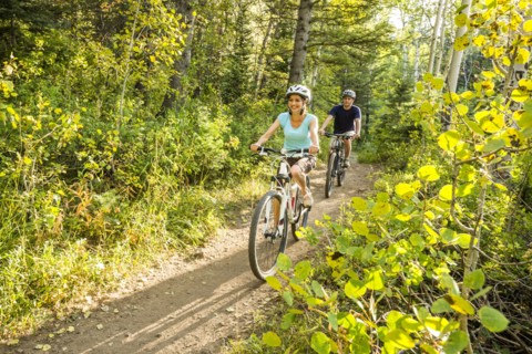 Caucasian couple riding mountain bikes