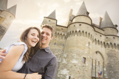 Caucasian couple smiling at castle