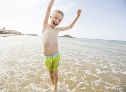Caucasian boy playing in waves on beach