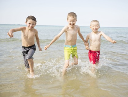 Caucasian boys playing in waves on beach