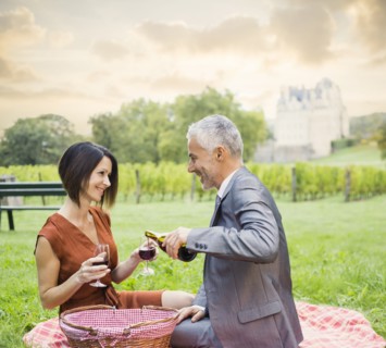 Caucasian couple enjoying wine at picnic