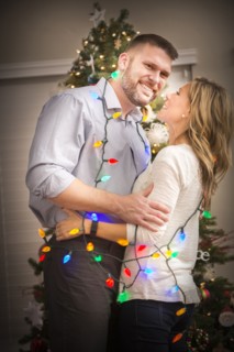 Caucasian couple wrapped in Christmas lights