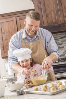 Caucasian father and daughter baking in kitchen