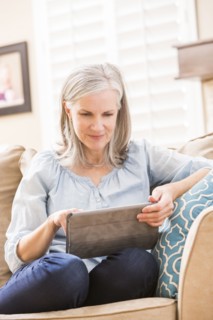 Caucasian woman using digital tablet on sofa