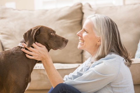 Caucasian woman hugging dog in living room