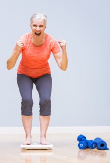 Caucasian woman cheering on scale