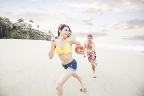 Caucasian couple playing on beach
