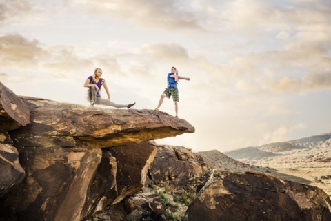 Caucasian couple stretching on rock formation