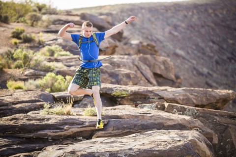 Caucasian teenage boy running on rock formation