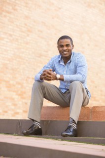 Smiling black man sitting on staircase