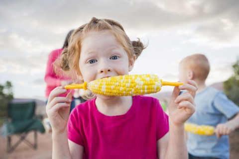 Caucasian girl eating corn on the cob