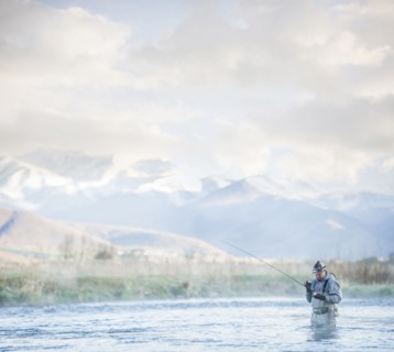 Caucasian man fly fishing in river