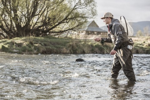 Caucasian man fly fishing in river