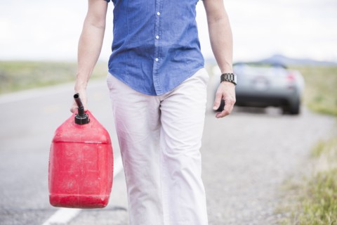 Caucasian man carrying gas on street