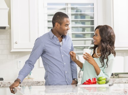 Black couple smiling in kitchen