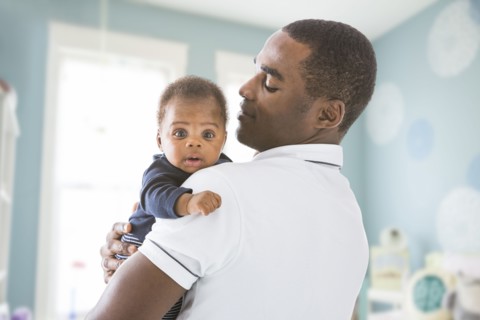 Black father holding baby son