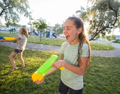 Wet Caucasian girls playing with squirt gun